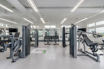 a gym with exercise equipment and weights on the floor